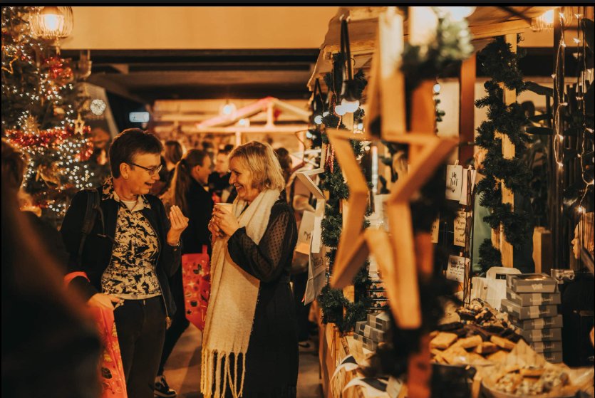 Kerstmarkt op locatie: medewerkers met een warm drankje bij de kraampjes