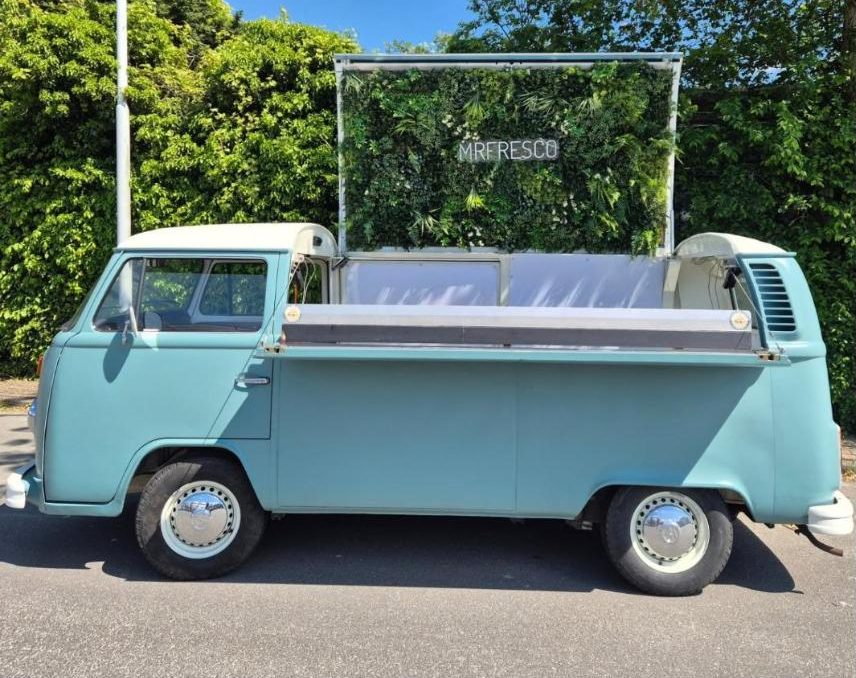 Light blue VW van with green plant wall