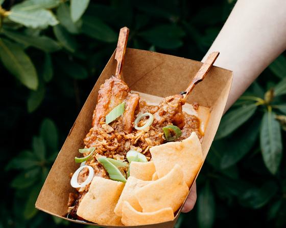 Chicken satay with prawn crackers in a paper tray